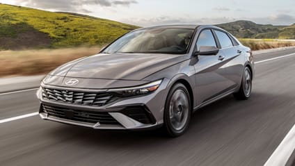 Hyundai Elantra -  front three quarter  driving shot on tarmac with countryside background