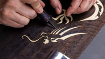 Close up shot of a person working on the in-laid dragon marquetry on the Rolls Royce Phantom Dragon one-off variant