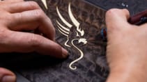 Close up shot of a person working on the in-laid dragon marquetry on the Rolls Royce Phantom Dragon with 297 pieces