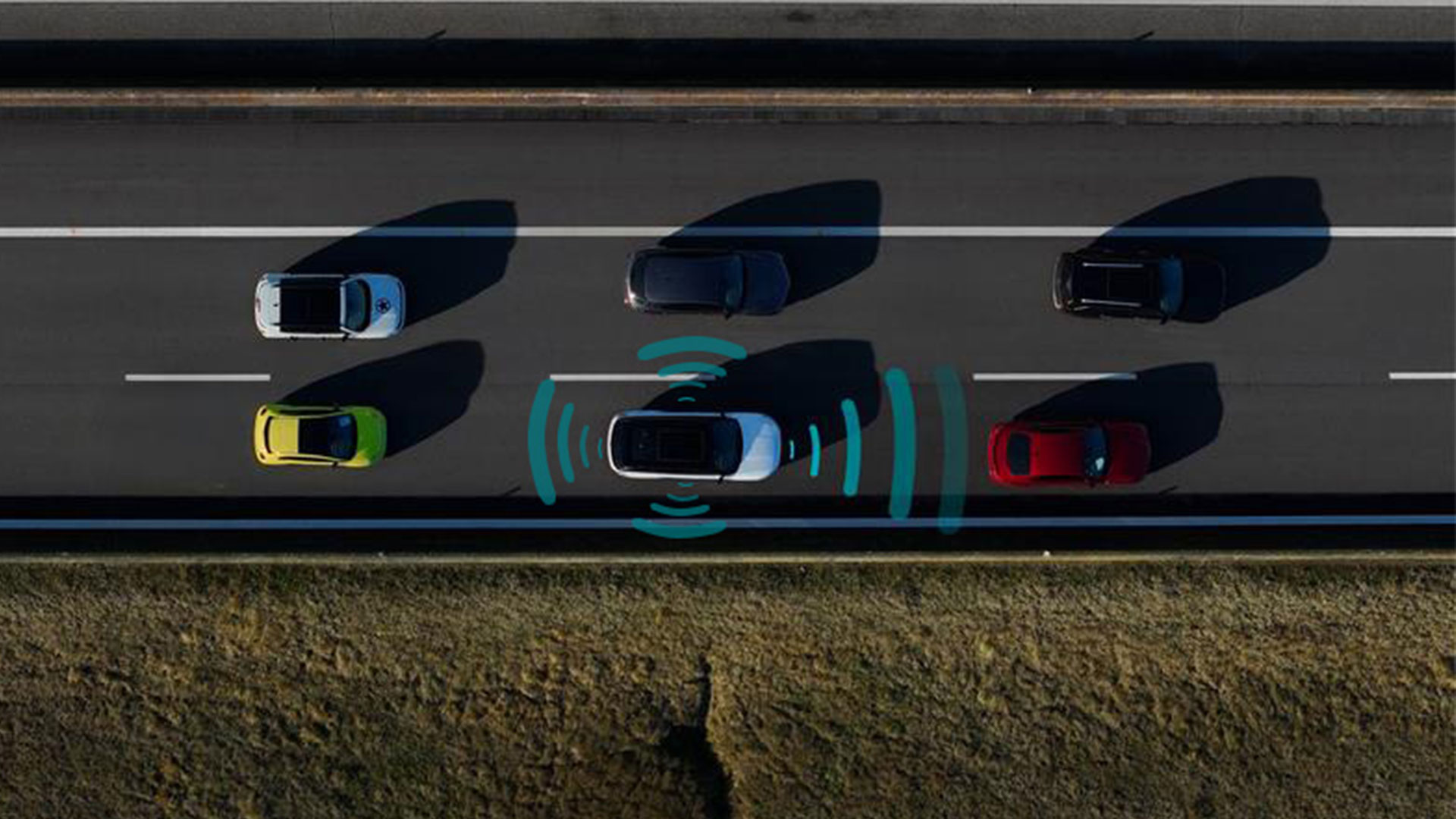 Birds eye view of vehicles on a motorway, with graphics around one indicating the self-driving sensors