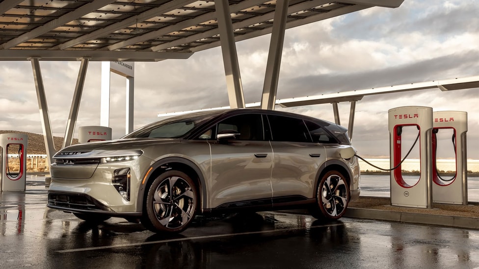 Lucid Gravity SUV parked and connected to a Tesla Supercharger