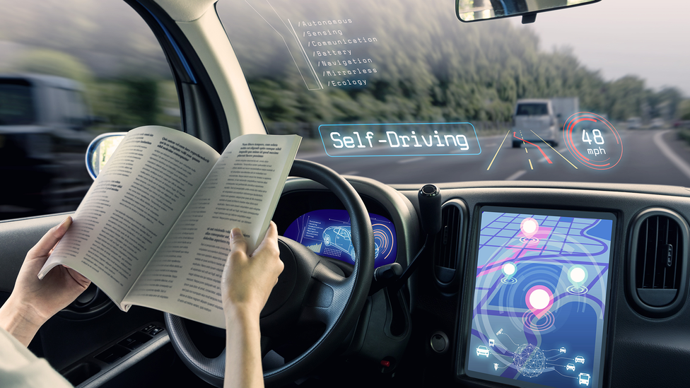 Digital render of a driver reading in a car in self-driving mode on the motorway, with graphics overlaid on the windscreen showing speed of travel