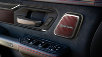 Close-up of a car door interior with a speaker that says Harman/Kardon.