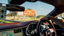 View from inside a moving vehicle with red interior, showing a road sign for the Hauts-de-France region.