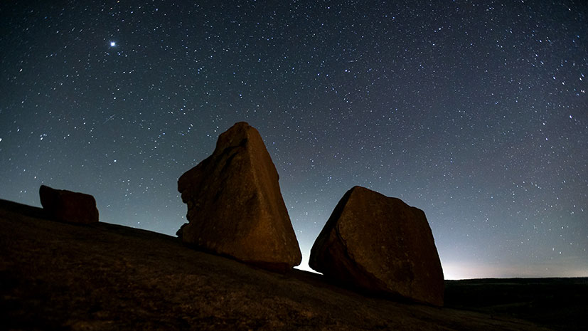 A clear night sky adorned with stars over striking rock formations in Fredericksburg, Texas Hill Country