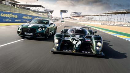 LMP car sitting alongside Bentley Le Mans edition on track - driving shot towards camera