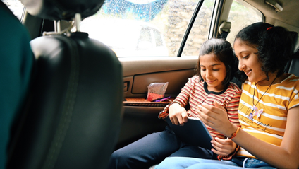 Two kids sat in the back of a car