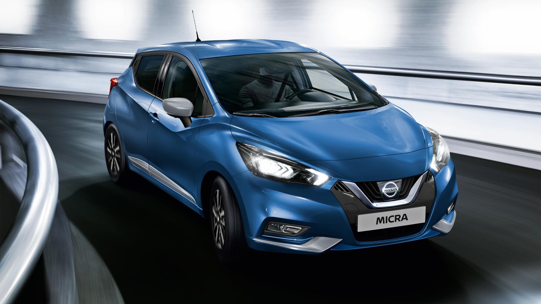 Driving shot of a blue Nissan Micra from driver front