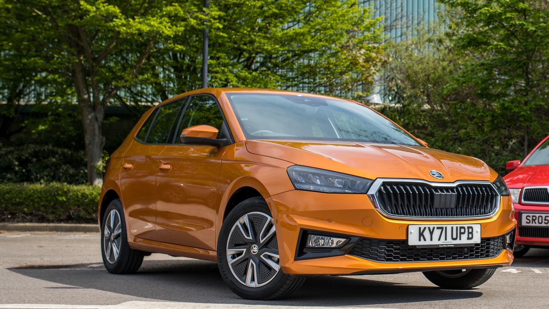 Static shot of orange Skoda Fabia from front driver side, with red Citigo partially in background