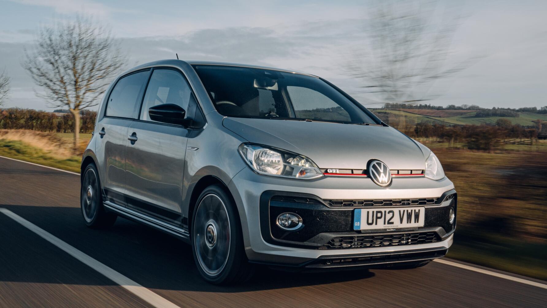 Driving shot of silver VW Up GTI from driver front side